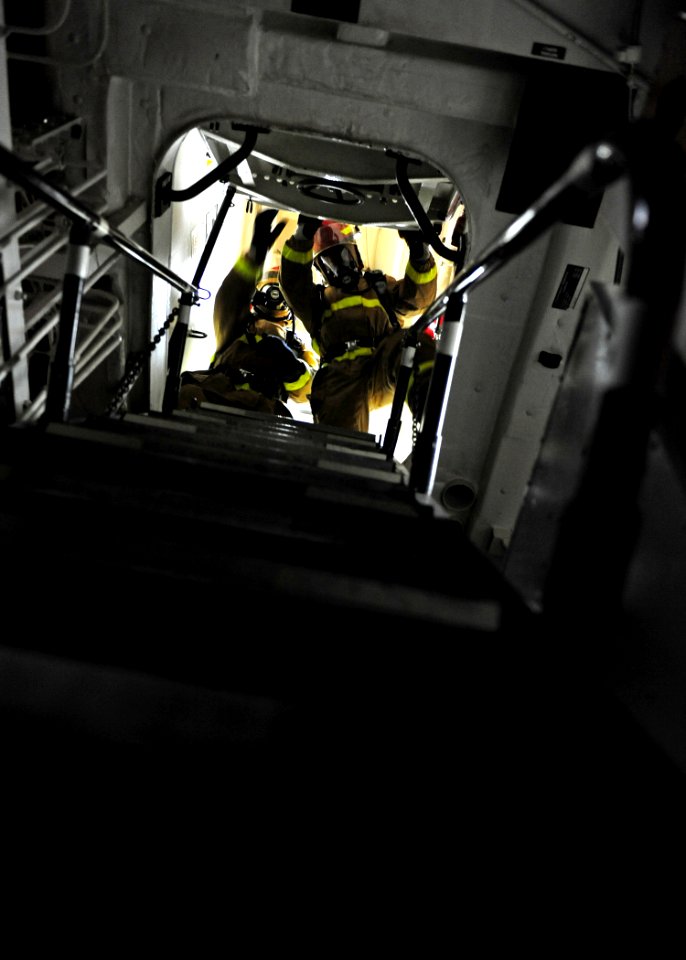 US Navy 111011-N-ED900-048 Boundary men raise a hatch to set a smoke boundary during a general quarters drill aboard the Arleigh Burke-class guided