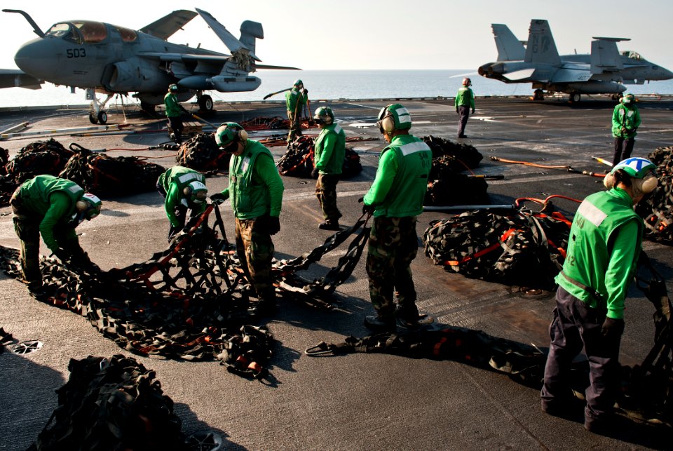 US Navy 111013-N-BT887-253 Logistics specialists bundle cargo nets during a vertical replenishment aboard the Nimitz-class aircraft carrier USS Joh