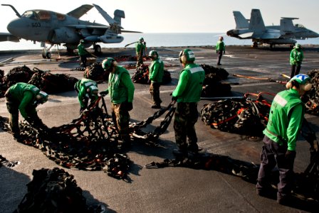 US Navy 111013-N-BT887-253 Logistics specialists bundle cargo nets during a vertical replenishment aboard the Nimitz-class aircraft carrier USS Joh
