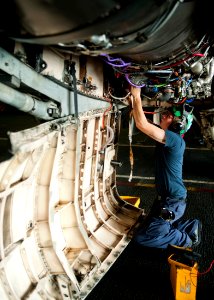 US Navy 111012-N-BT887-217 Aviation Electrician's Mate Airman Michael Sawyer performs maintenance on the engine of an F-A-18C Hornet