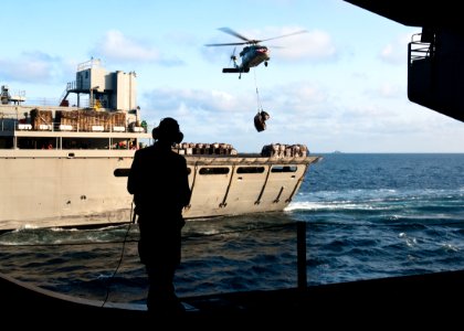 US Navy 111013-N-BT887-001 Airman Michael Ryan, from Tempe, Ariz., watches as an MH-60S Sea Hawk helicopter delivers cargo