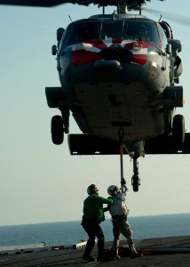 US Navy 111013-N-BT887-194 Lt. Michael Stamerra attaches a hook to an MH-60S Sea Hawk helicopter assigned to the Eightballers of Helicopter Sea Com
