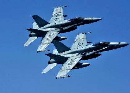 US Navy 111017-N-RJ456-317 Two F-A-18C Hornets assigned to the Golden Dragons of Strike Fighter Squadron (VFA) 192 fly over the aircraft carrier US