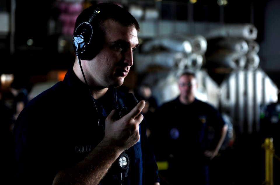 US Navy 111013-N-VN693-347 Interior Communications Electrician Fireman Brian Guilliams uses a sound-powered telephone to communicate below decks