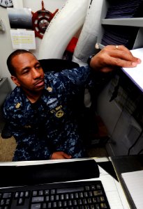 US Navy 111017-N-XE109-134 Master Chief Navy Counselor Kenneth Boben files records in the career counselor's office aboard the aircraft carrier USS