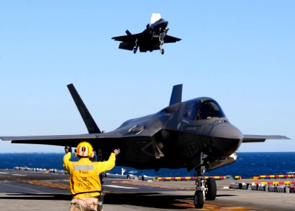US Navy 111015-N-UM734-932 An aviation boatswain's mate maneuvers BF-04, front, the U.S. Marine Corps variant of the F-35B Lighting II Joint Strike