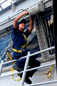 US Navy 111019-N-QL471-397 Electrician's Mate Fireman Julio C. Diaz replaces windshield wipers outside the pilothouse aboard the aircraft carrier U