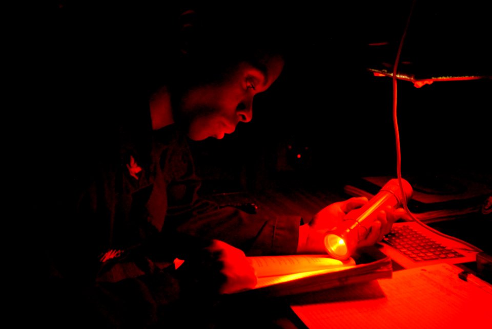 US Navy 111017-N-DU438-066 Quartermaster 3rd Class Lonnie Williams reviews the ship's deck log during a quartermaster watch in the ship's pilot hou