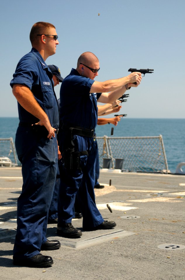 US Navy 111014-N-XQ375-088 Sailors aboard the guided-missile destroyer USS Mitscher (DDG 57) fire 9mm pistols during a small arms qualification cou