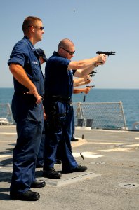 US Navy 111014-N-XQ375-088 Sailors aboard the guided-missile destroyer USS Mitscher (DDG 57) fire 9mm pistols during a small arms qualification cou photo