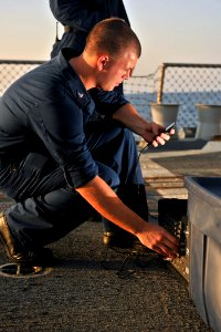 US Navy 111016-N-YZ751-013 Interior Communications Electrician 3rd Class Richard G. Hoyt sets up audio equipment for a movie night