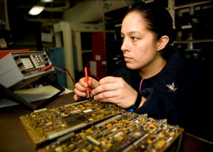 US Navy 111018-N-RJ456-015 Aviation Electronics Technician 3rd Class Caitlin Caldwell, from Melbourne, Fla., inspects a circuit board