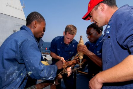 US Navy 111020-N-DU438-069 Damage Controlman 1st Class Peter Martinez instructs Sailors on how to patch a simulated ruptured pipe during a training