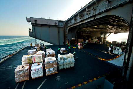 US Navy 111020-N-BT887-481 Sailors move cargo from an aircraft elevator during a replenishment at sea aboard the Nimitz-class aircraft carrier USS