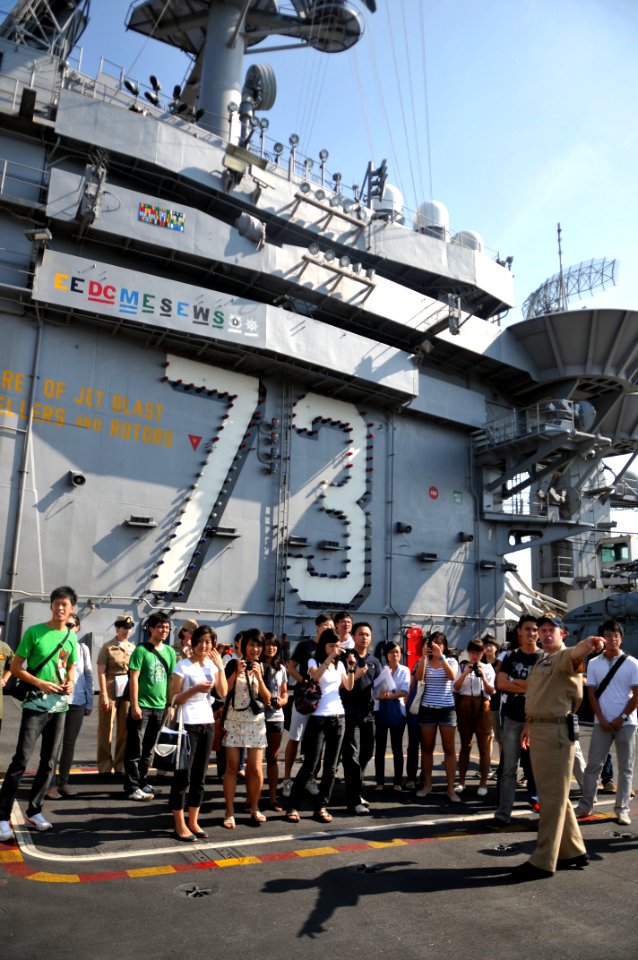 US Navy 111015-N-WW409-145 Lt. Cmdr. Dave Hecht gives a tour of the aircraft carrier USS George Washington (CVN 73) to students from the Singapore
