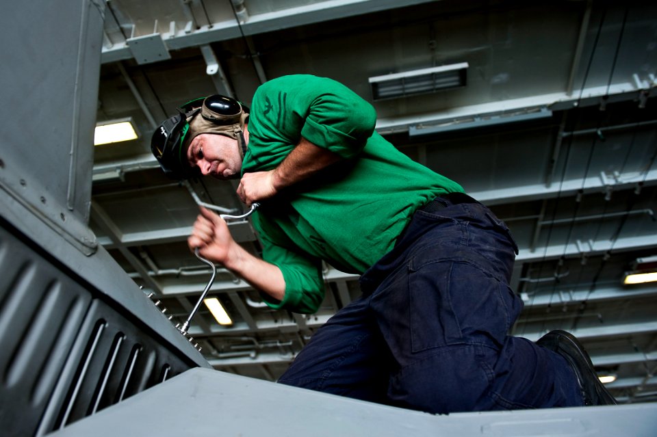 US Navy 111019-N-BT887-028 Aviation Structural Mechanic 2nd Class Craig Heady, removes a panel from an F-A-18C Hornet from the Warhawks of Strike F