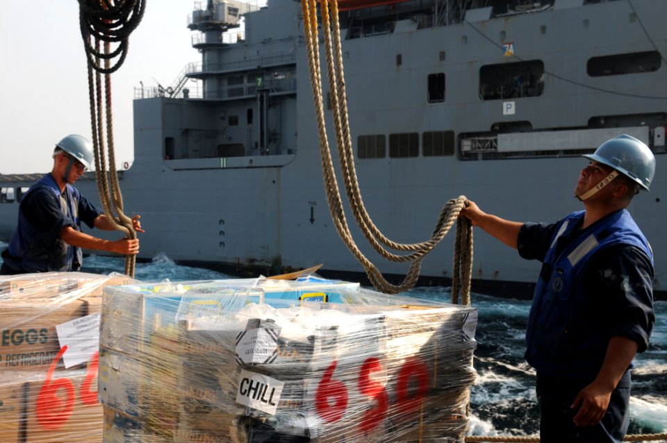 US Navy 111020-N-XQ375-377 Boatswain's Mate Seamen Daniel Nogal, left, and Lucio Robles take lines off a pallet of stores sent to the guided-missil