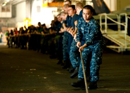 US Navy 111020-N-BT887-374 Operations Specialist 3rd Class Franklin Espinosa heaves a line during a replenishment at sea