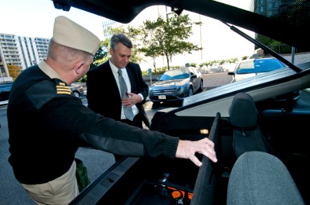 US Navy 111020-N-PM781-008 Tom Hicks, right, Deputy Assistant Secretary of the Navy for Energy, looks at the battery compartment of a Chevrolet Vol