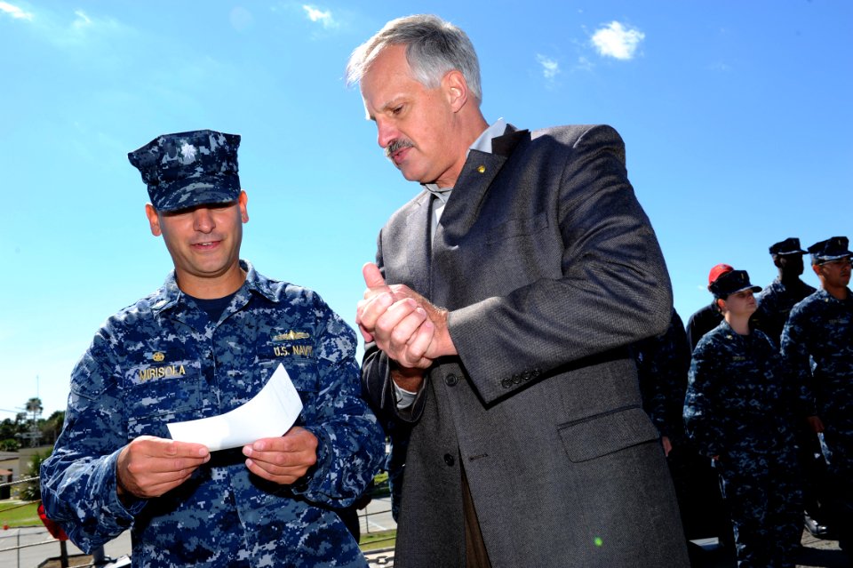 US Navy 111020-N-DD445-001 Cmdr. Peter Mirisola, the commanding officer of the guided-missile frigate USS Underwood (FFG 36), receives a $1,000 che