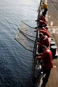 US Navy 111018-N-XQ375-322 Sailors raise the nets on the flight deck of the guided-missile destroyer USS Mitscher (DDG 57) after conducting flight