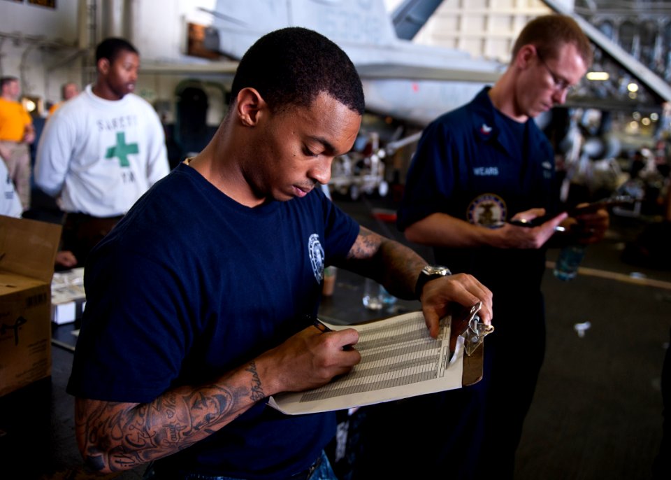US Navy 111020-N-BT887-585 Logistics Specialist 3rd Class Jarrad Harper, from Houston, logs cargo statistics during a replenishment at sea