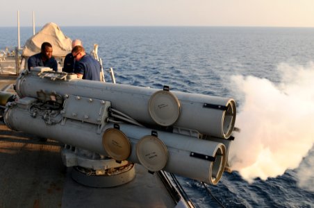 US Navy 111019-N-XQ375-346 Sailors watch as Sonar Technician Seaman Darian Johnson fires an air slug from a MK-32 surface vessel torpedo tube aboar photo