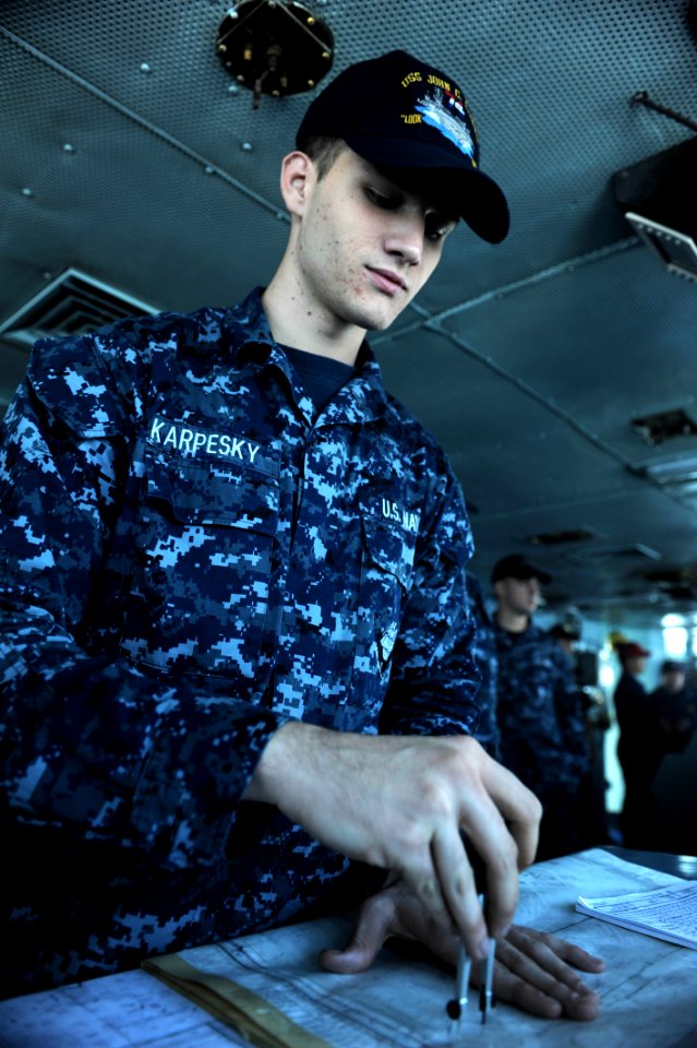 US Navy 111020-N-OY799-033 Quartermaster Seaman Jonathan Karpesky, from Corpus Christi, Texas, plots the ship's position in the bridge aboard the N