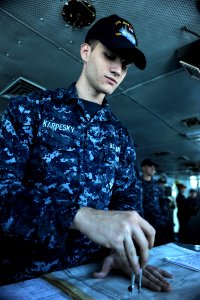 US Navy 111020-N-OY799-033 Quartermaster Seaman Jonathan Karpesky, from Corpus Christi, Texas, plots the ship's position in the bridge aboard the N
