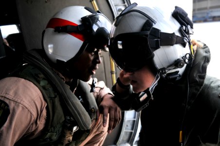 US Navy 111022-N-WW409-022 Naval Air Crewman 3rd Class Maurice Long, left, and Lt. j.g. Becca Smith conduct preflight checks before flying to Bangk photo