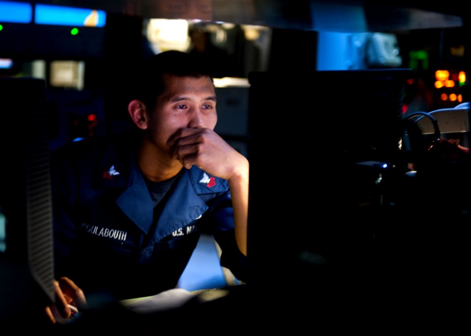 US Navy 111022-N-FI736-091 Operations Specialist 1st Class Phillip Koulabouth monitors message traffic in the combat information center aboard the