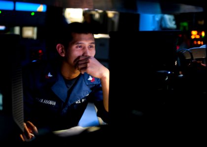 US Navy 111022-N-FI736-091 Operations Specialist 1st Class Phillip Koulabouth monitors message traffic in the combat information center aboard the