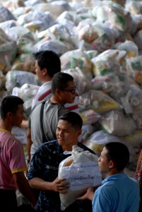 US Navy 111023-N-WW409-574 Gas Turbine System Technician (Mechanical) 2nd Class Carlo Pamintuan delivers prepared food kits