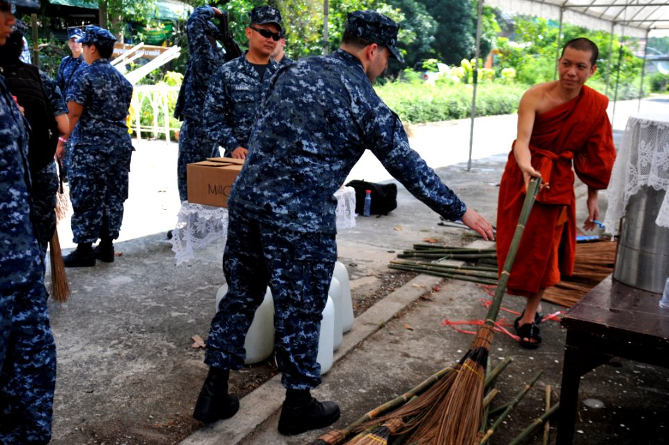 US Navy 111024-N-WW409-008 Sailors assigned to the guided-missile destroyer USS Mustin (DDG 89) gather brooms from a Buddhist monk during a communi