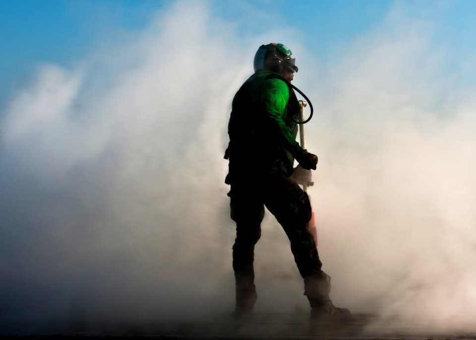 US Navy 111025-N-BT887-075 Aviation Boatswain's Mate (Equipment) Airman David Worrell collects a hold-back bar after launching aircraft aboard the
