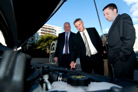 US Navy 111020-N-PM781-009 Tom Hicks, center, Deputy Assistant Secretary of the Navy for Energy, looks at the engine of a Chevrolet Volt electric c