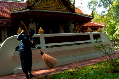 US Navy 111024-N-EA192-009 Navy Counselor 1st Class Charhonda King sweeps a walkway during a community service project at the Wat Jitapawan College
