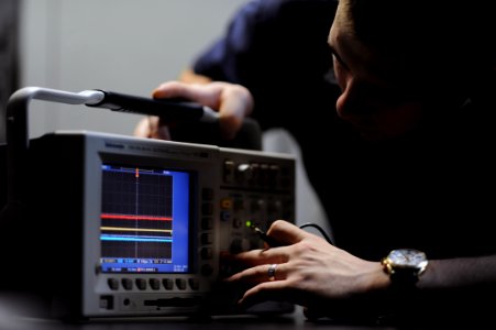 US Navy 111022-N-XE109-039 Electronics Technician 2nd Class Craig A. Bishop troubleshoots an oscilloscope aboard the aircraft carrier USS George H