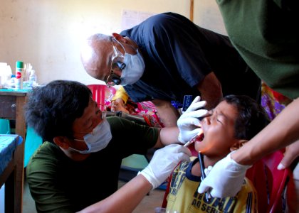 US Navy 111023-N-VP123-169 Capt. Roland McCoy, a dentist assigned to Commander, Task Force 73, observes a Royal Cambodian Armed Forces dentist admi