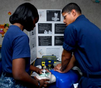 US Navy 111021-N-KA046-006 Hospital Corpsman 2nd Class Miguel Hernandez, right, demonstrates the correct CPR technique for Seaman Destiny Walker du photo