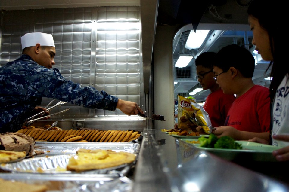 US Navy 111021-N-ZC343-568 A Sailor serves dessert to 5th graders from Gerald R. Ford Elementary School in Indian Wells, Calif