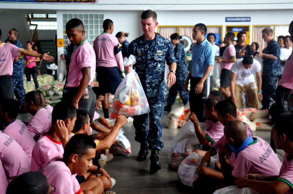 US Navy 111023-N-WW409-350 Cmdr. Scott Tait, commanding officer of the guided missile destroyer USS Mustin (DDG 89) hands service members from the