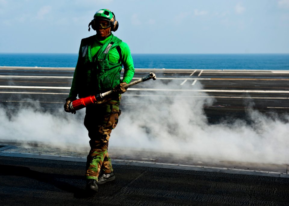 US Navy 111023-N-BT887-045 Aviation Boatswain's Mate (Equipment) David Worrell collects a hold-back bar