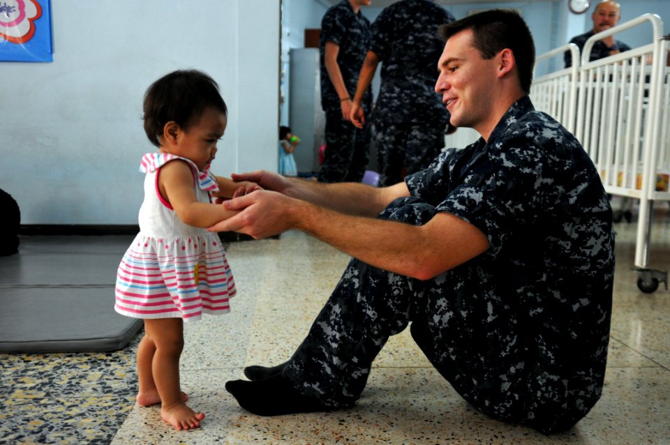 US Navy 111025-N-WW409-058 Lt. j.g. Tim Cox, assigned to the guided-missile destroyer USS Mustin (DDG 89), plays with a child at the Pattaya Orphan