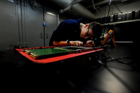 US Navy 111022-N-XE109-004 Electronics Technician 2nd Class Christopher R. Witte tests a circuit card aboard the aircraft carrier USS George H.W. B