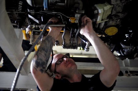 US Navy 111024-N-SF704-268 Aviation Machinist's Mate 2nd Class Brandon Agan from Palmdale, Fla., inspects the control cables of an F-414 engine