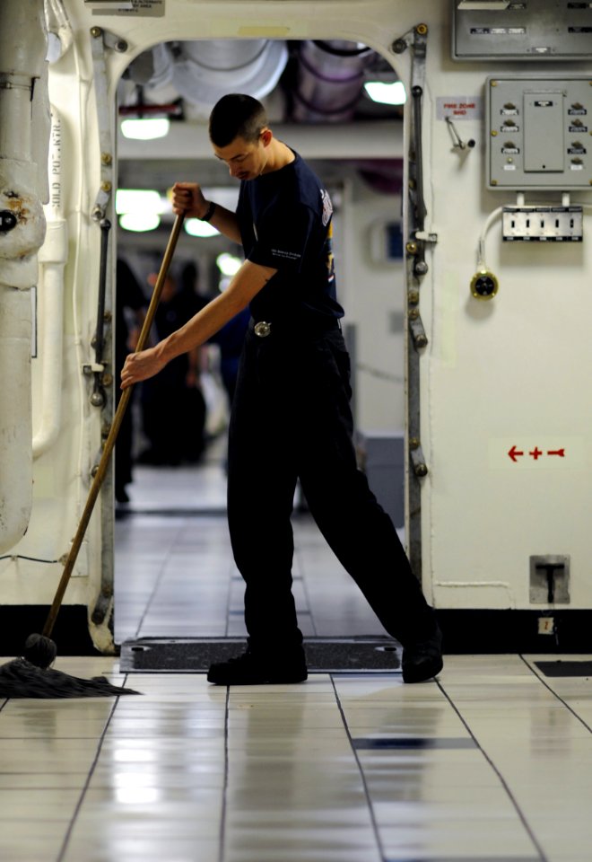 US Navy 111023-N-XE109-089 Aviation Boatswain's Mate (Handling) Airman Larry D. Dunkle mops the deck aboard the aircraft carrier USS George H.W. Bu