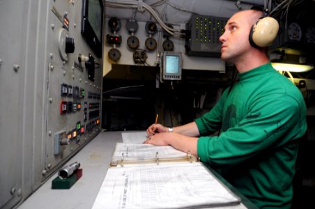 US Navy 111022-N-JD217-010 Aviation Boatswain's Mate (Equipment) 3rd Class Matthew J. Boyer records catapult steam pressure during flight operation