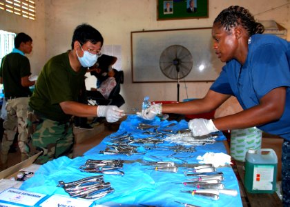 US Navy 111022-N-VP123-059 Hospital Corpsman 2nd Class Rochelle Quintyne, assigned to Commander, Task Force 73, passes sterile instruments to a Roy