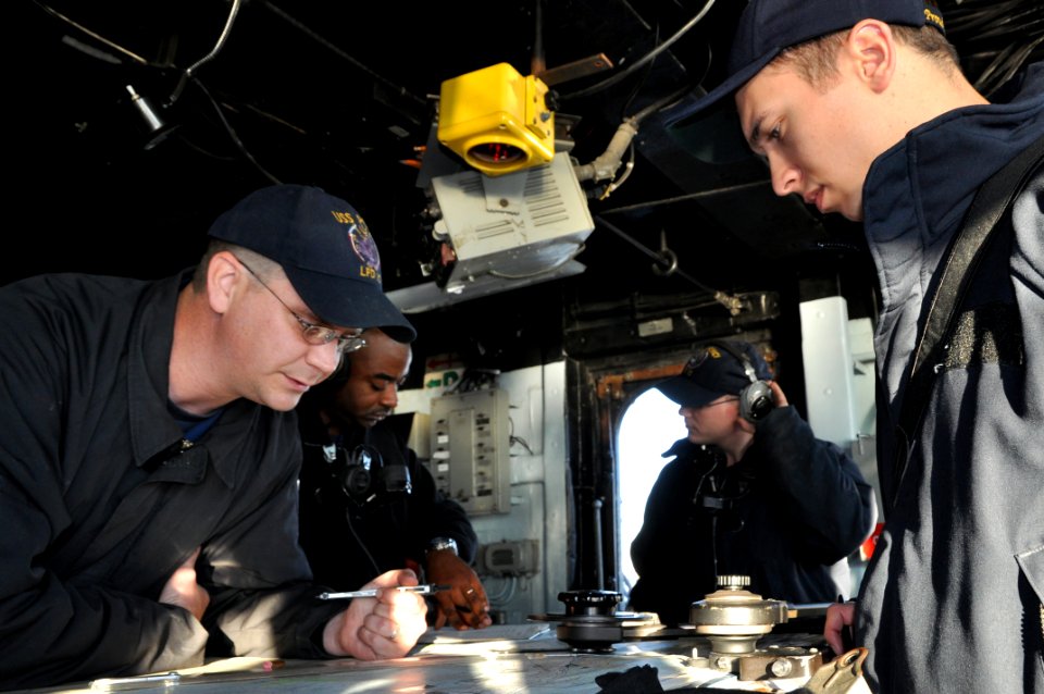 US Navy 111025-N-YX169-370 Quatermaster 2nd class Deron Murphree, left, and Lt. j.g. Jace Myers, ship's navigator, chart the position of the amphib